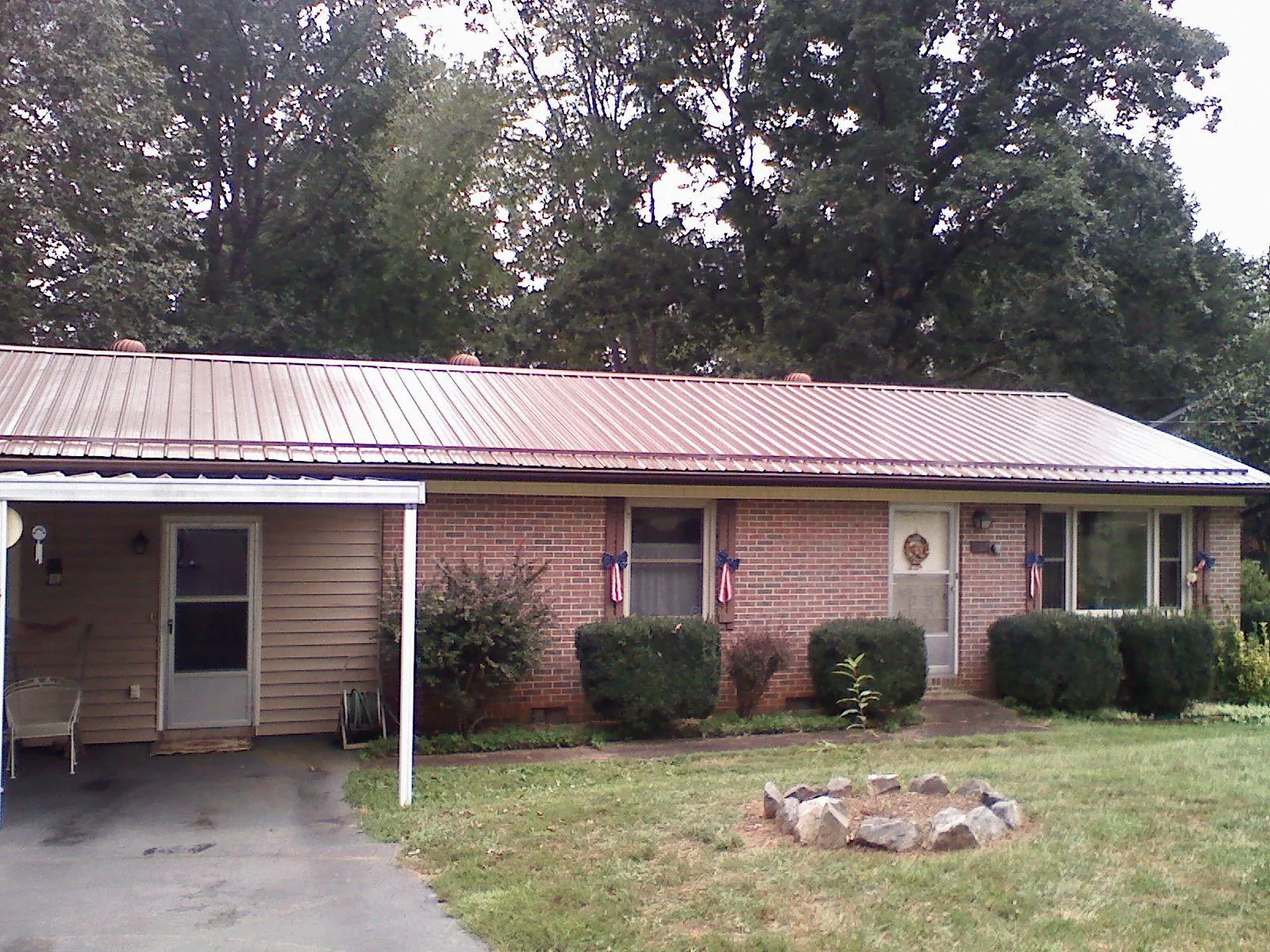 Bronze metal roof and carport on a brick ranch home — Roof Repair work by our crew in New Berlin